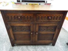 A two-drawer, twin-door Priory style oak sideboard,