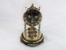 A mid-20th century 400 Day Anniversary clock under a glass dome,