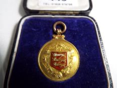 A 9ct gold and enamel runners up medal from the Lancashire FA Amateur Cup awarded to A H Fox for