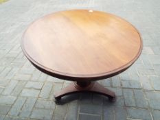 An antique mahogany dining table on cast