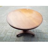 An antique mahogany dining table on cast