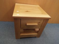 A contemporary light oak side table with