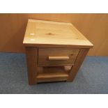 A contemporary light oak side table with