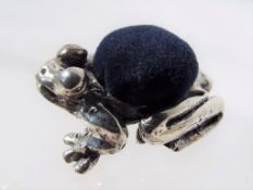 A silver pin cushion in the form of a fr