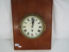 A ship's bulkhead clock, Roman numerals on a white metal dial, with subsidiary seconds dial,