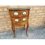 A walnut veneer chest of two drawers with oval hand painted ceramic panels mounted in gilded metal