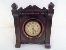 A mahogany cased wind-up alarm clock, Arabic numerals on a white dial with two subsidiary dials,