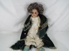 An early 20th century German dressed doll dating to ca 1908, bisque head, cloth body,