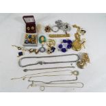 A collection of vintage costume jewellery to include a silver bracelet with padlock and safety