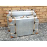 Two graduated vintage style metal suitcases with leather and wooden trim