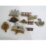 Ten militaria cap badges.