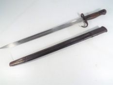 A bayonet with leather scabbard, inscribed to the blade with broad arrow / crow's foot, U X E,