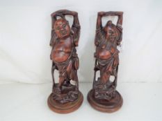 Two highly carved treen Japanese figures on plinths