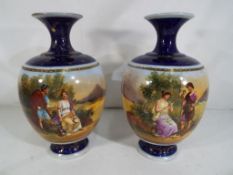A pair of Royal Vienna style ceramic vases decorated with couples in a landscape scene on a blue