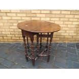 An oak drop leaf occasional table with barley twist supports,
