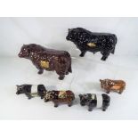 Two decanters in the style of a brown bull and a black bull each containing Rutherfords,