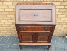 A drop fronted bureau over a cupboard and one drawer, approximate height 102 cm x 70 cm x 47 cm.