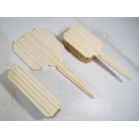 A three piece Art Deco ivory dressing table set comprising hand mirror,