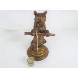 A 19th century Continental brass figural inkwell formed as a standing bear holding a staff with
