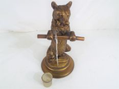 A 19th century Continental brass figural inkwell formed as a standing bear holding a staff with