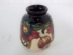 Moorcroft - a Moorcroft vase decorated in the Anna Lily pattern, approximate height 8.5 cm.
