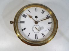 A Ship's bulkhead clock, heavy brass case with opening glazed bezel,