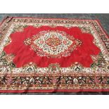 A large traditional rug / carpet with a floral design on a burgundy ground,