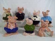 A set of seven Nat West pig money banks marked Wade, Cousin Wesley approx size 15.
