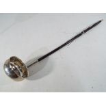 A silver punch ladle with inscribed this