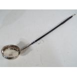 A silver punch ladle with inscribed lion