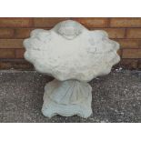 A reconstituted stone bird bath