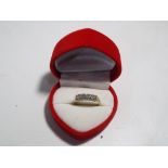 A 14 carat gold ring set with five diamo