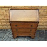 A drop fronted bureau over three drawers