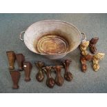 A metal wash tub containing three sets of cast iron bath feet,