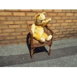 A vintage bear, single jointed limbs, glass eyes, stitched snout,