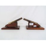 Two good quality miniature brass cannons on wooden plinth, approximately 16.