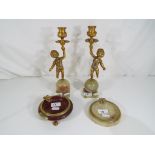 A pair of marble gilded candlesticks depicting putti with matching ashtrays (4)