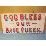 A hand painted vintage sign bearing the motto 'God Bless our Rose Queen' presumed to be from a