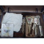 A vintage suitcase containing a quantity of vintage linen, dressing table sets, plated bowl,