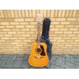 A Shaftesbury six string acoustic guitar with protective case and guitar strap