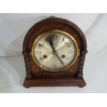 An oak cased mantel clock, Jacobean style decoration,