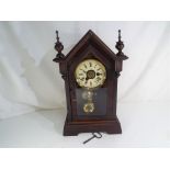 A small kitchen steeple clock, timepiece with alarm, the case having two turned finials,