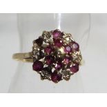 A lady's hallmarked 9ct gold cluster ring set with diamonds and garnets, size N, approx weight 2.