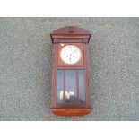 An Edwardian polished mahogany cased wall clock, silvered dial with Arabic numerals,