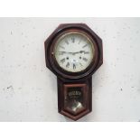 A mahogany drop dial style wall clock with ebonised accent to the case, brass glazed bezel,