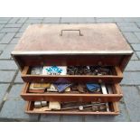 A wooden tool chest containing 5 internal drawers comprising a quantity of vintage tools and
