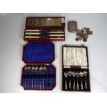 A George V silver hallmarked cigarette case, Birmingham assay 1910, two case sets of plated spoons,