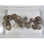 A silver hallmarked bracelet with a quantity of three pence pieces attached, predominantly pre-1947,