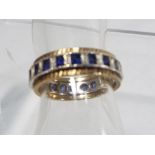 A lady's 9 carat gold and silver full eternity ring set with diamond chips and sapphire,