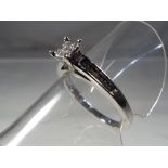 A lady's 14 carat white gold engagement ring set with nine princess cut diamonds in the head and